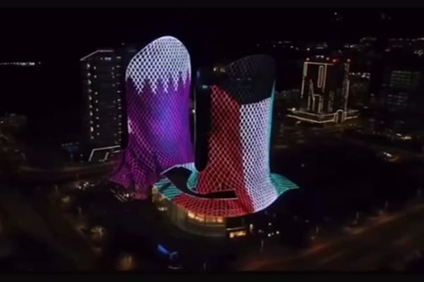 A skyscraper displaying a complex video animation across its entire facade